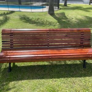 banco de madera en un jardin con piscina