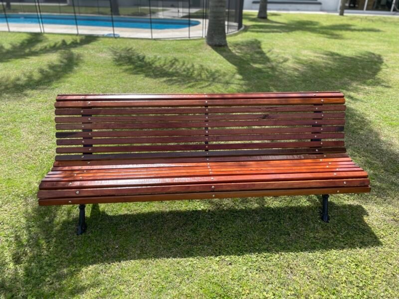 banco de madera en un jardin con piscina