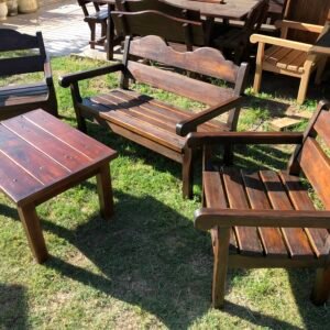 Conjuntos de sillones de madera con mesa ratona en un jardín.