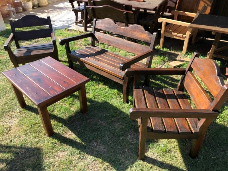 Conjuntos de sillones de madera con mesa ratona en un jardín.