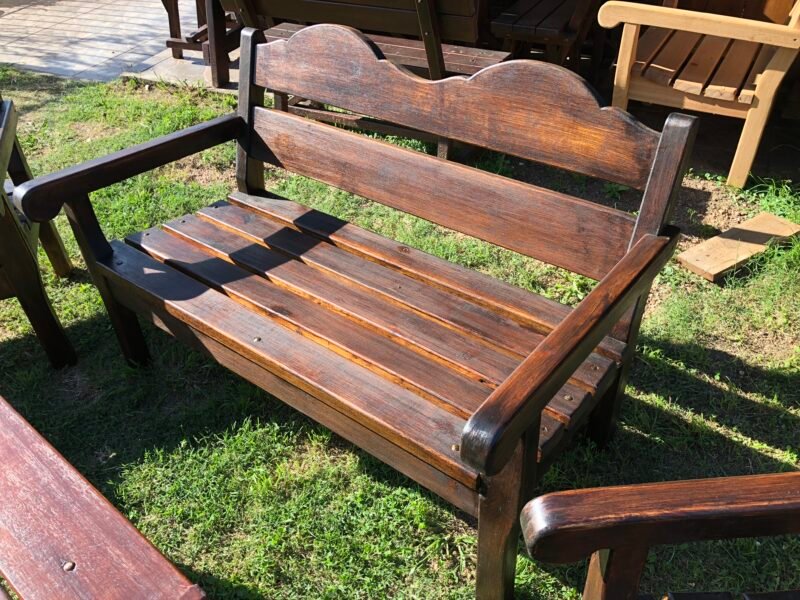 Sillon de madera para 2 personas en un jardín.