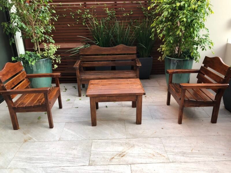 Juego de sillas de madera con mesa ratona de madera en el centro.